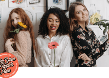 three girls stand with flower stems